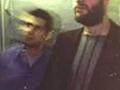 Two men walking up stairs, film sprockets on either side.